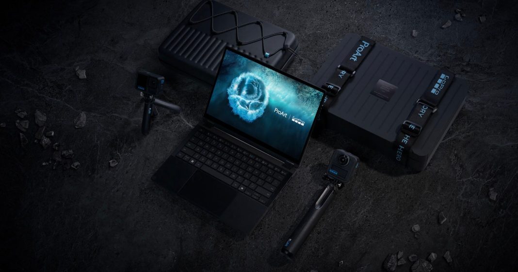 GoPro and Asus Are Making a Co-Branded ProArt Laptop A laptop with a blue glowing logo on screen is placed on a dark surface, surrounded by two suitcases and two action cameras on tripods. The arrangement suggests travel or outdoor content creation.